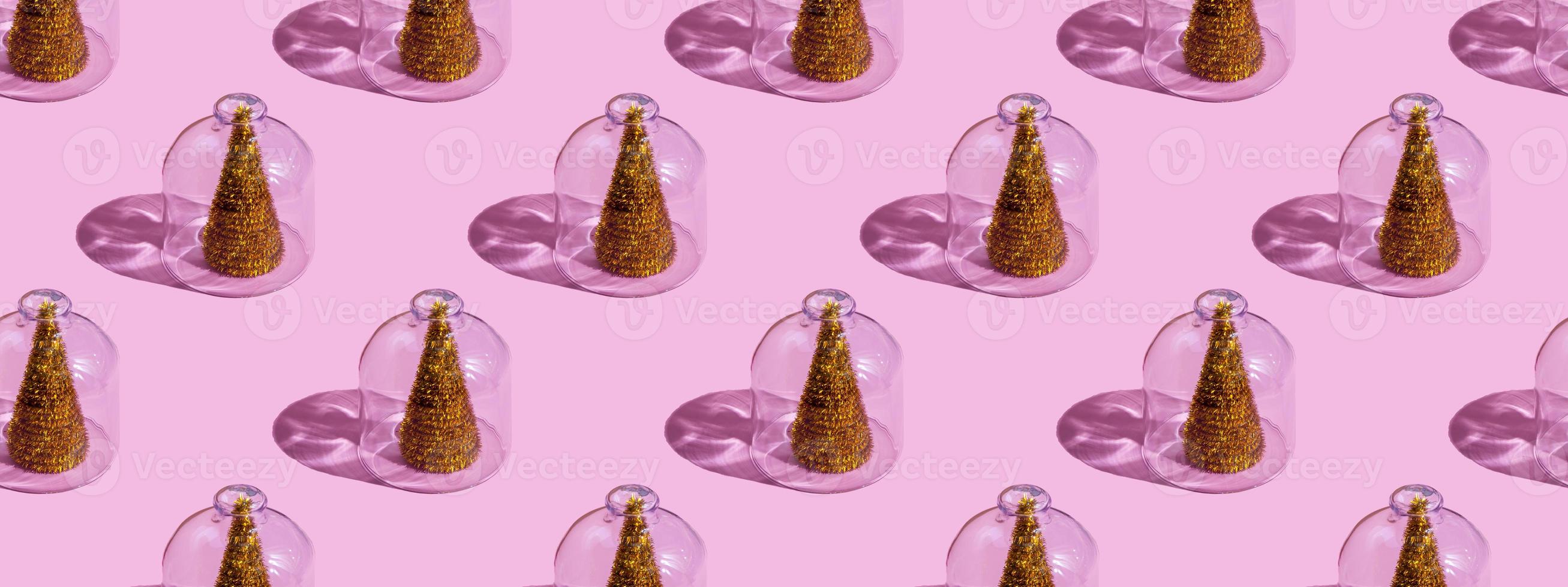 albero di natale sotto vetro su uno sfondo rosa. concetti di natale con copia spazio. concetto di capodanno e natale in quarantena. campione di quarantena. foto