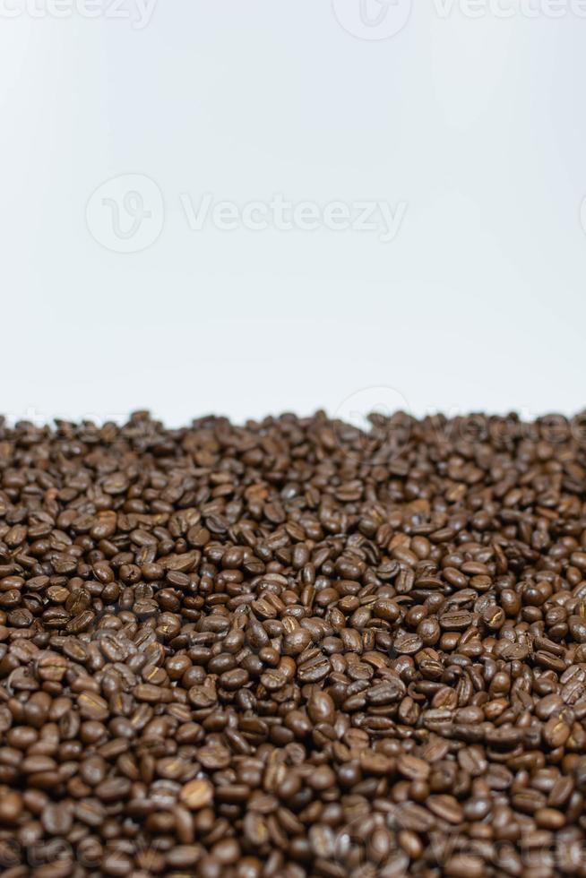 chicchi di caffè sparsi su uno sfondo bianco foto verticale