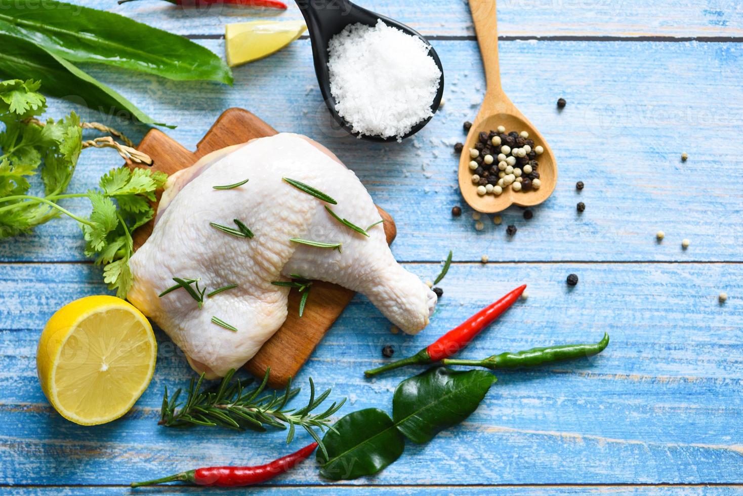 coscia di pollo cruda su legno per cucinare cibo asiatico tailandese pollo al rosmarino limone, vista dall'alto foto