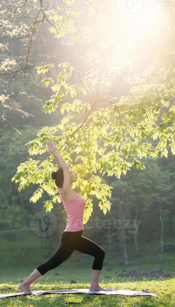 giovane bella donna asiatica che pratica yoga foto