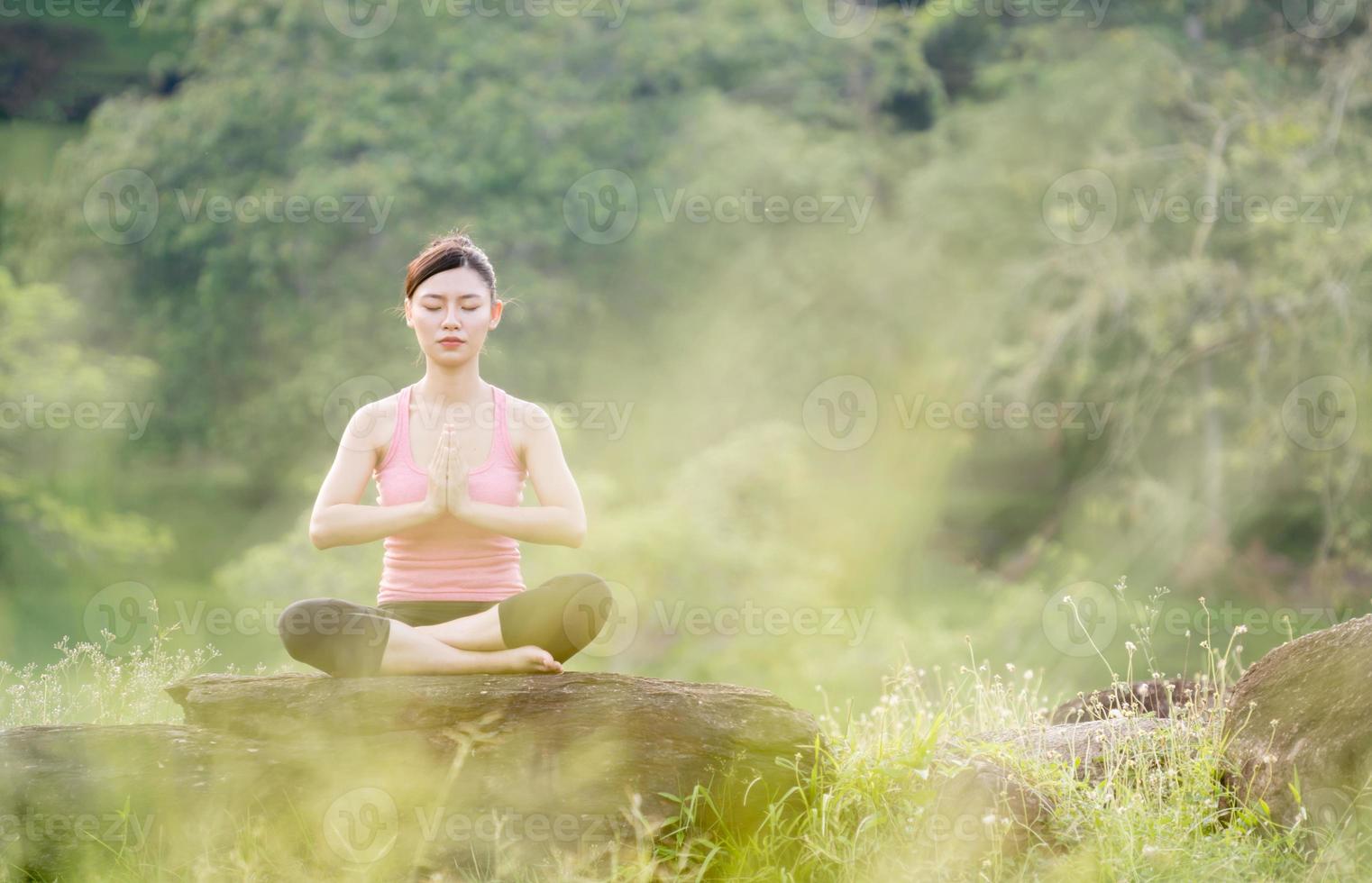 giovane bella donna asiatica che pratica yoga foto