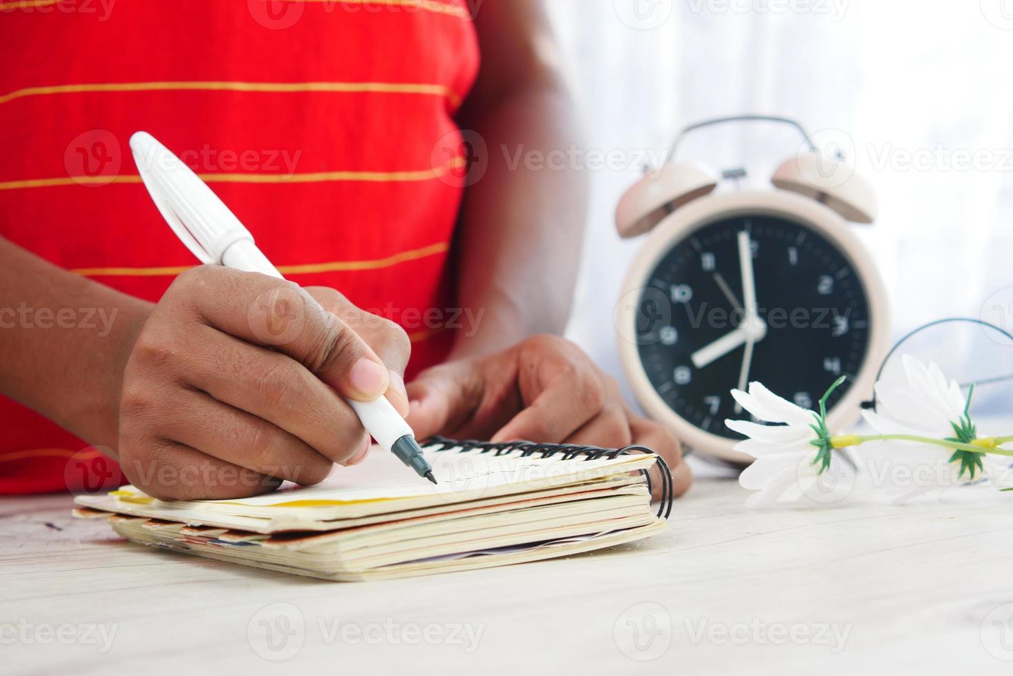 bambino ragazzo scrittura a mano sul blocco note. foto