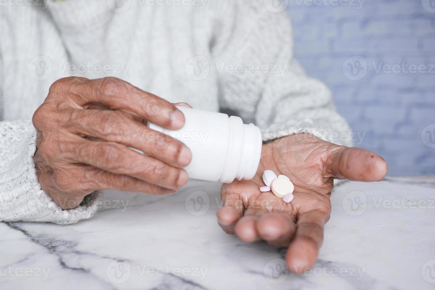 donne anziane che prendono medicine mentre sono sedute foto