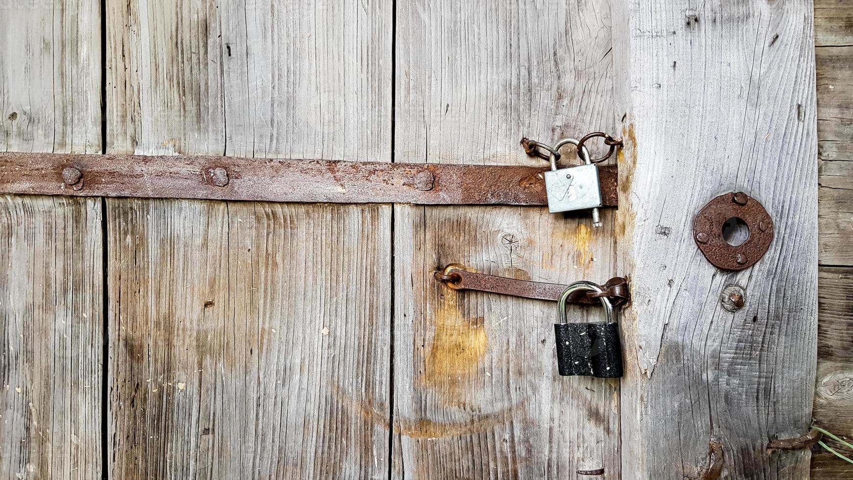 vecchio lucchetto vintage in metallo su una porta di legno chiusa di una vecchia casa colonica. il vero stile del villaggio. avvicinamento. concentrarsi sul castello. fondo in legno, trama. copia spazio foto