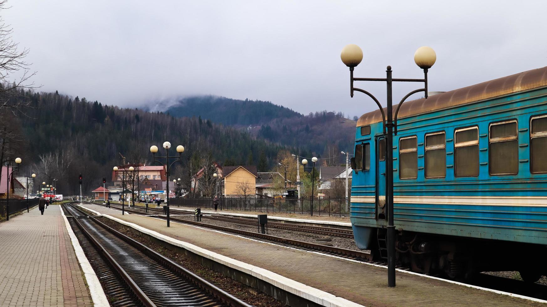 Ucraina, yaremche - 20 novembre 2019. treno alla stazione su uno sfondo di montagne. vagoni ferroviari unici sulla piattaforma nella città di yaremche. vecchio treno passeggeri diesel. stazione ferroviaria. foto