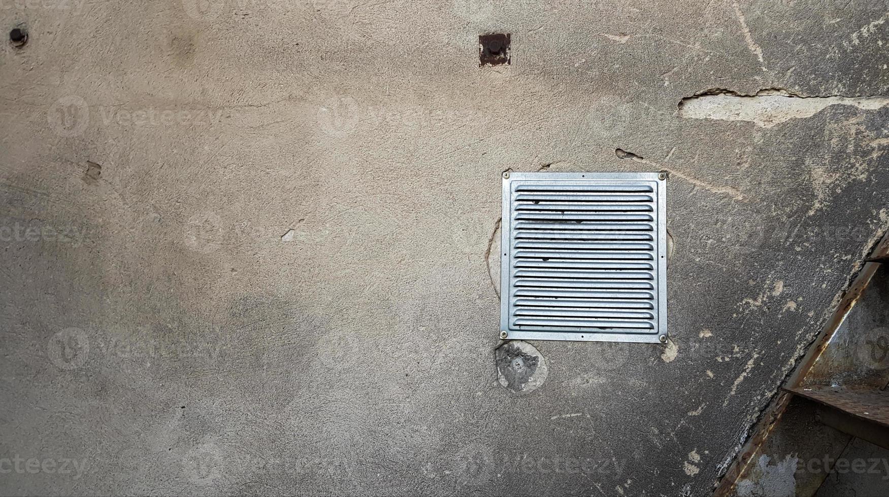 prese d'aria invecchiate con persiane bianche su sfondo grigio cemento. vecchia ventilazione nell'angolo destro del muro di cemento. griglia di ventilazione nel muro di cemento di un edificio moderno foto