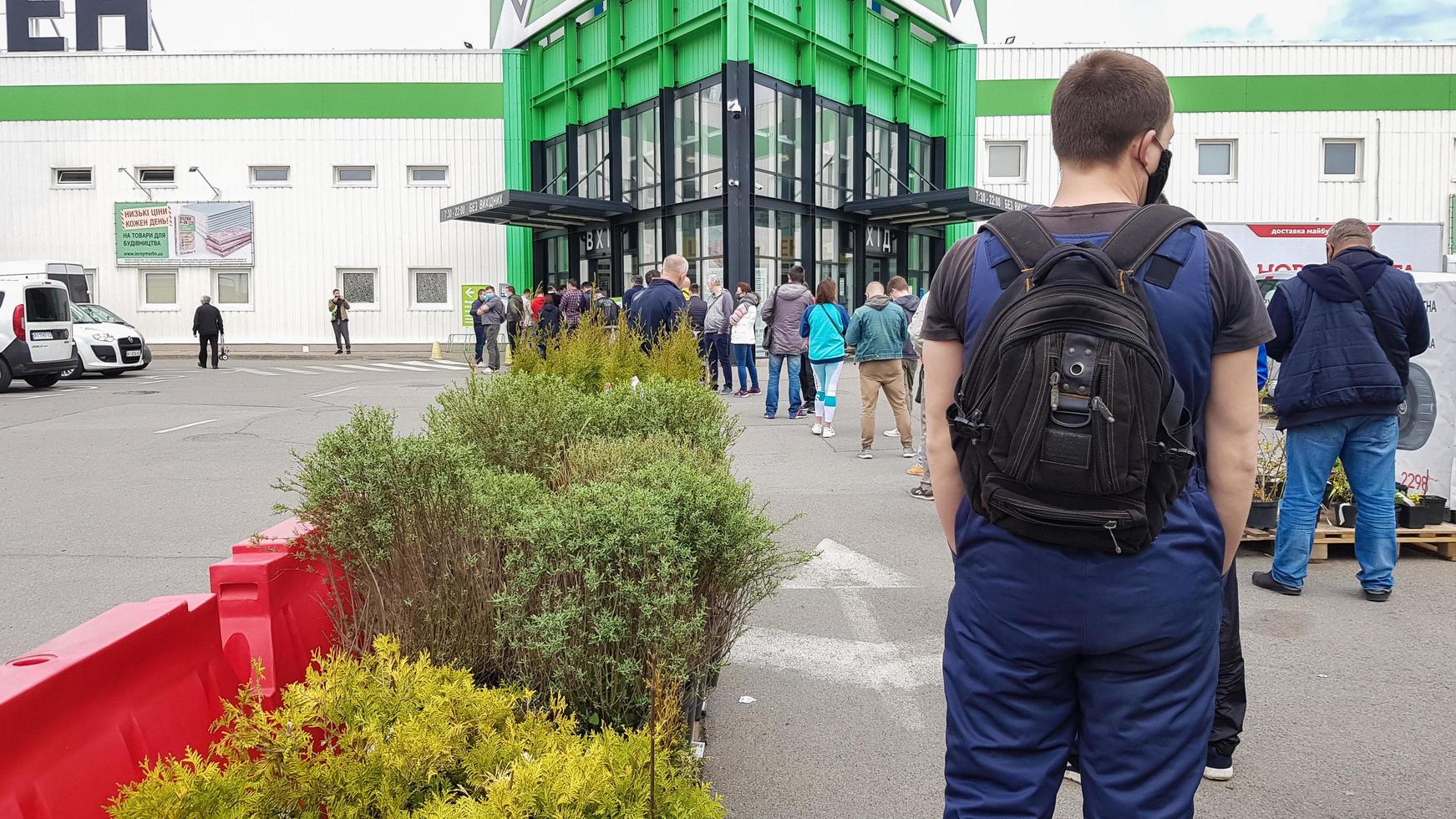 ucraina, kiev - 7 maggio 2020. molte persone si mettono in fila vicino a un supermercato edile o a un negozio di alimentari, aspettando in fila per entrare a causa della direttiva sulla sicurezza della pandemia di coronavirus. restrizione della folla foto