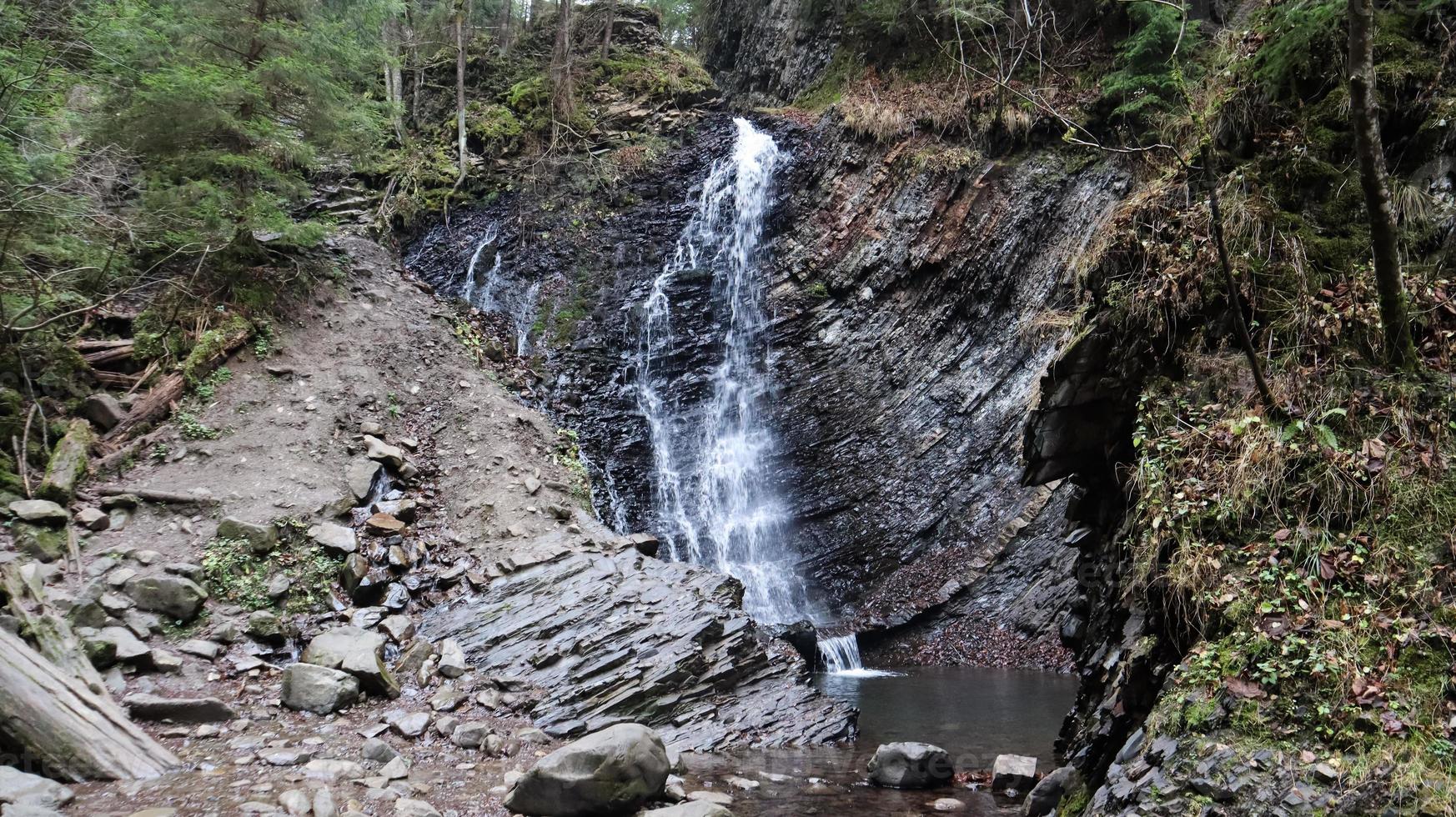 cascate in un piccolo canyon con pareti in pietra. bella cascata in montagna. fiume nei Carpazi nella foresta autunnale di montagna. vista panoramica, il movimento dell'acqua. foto