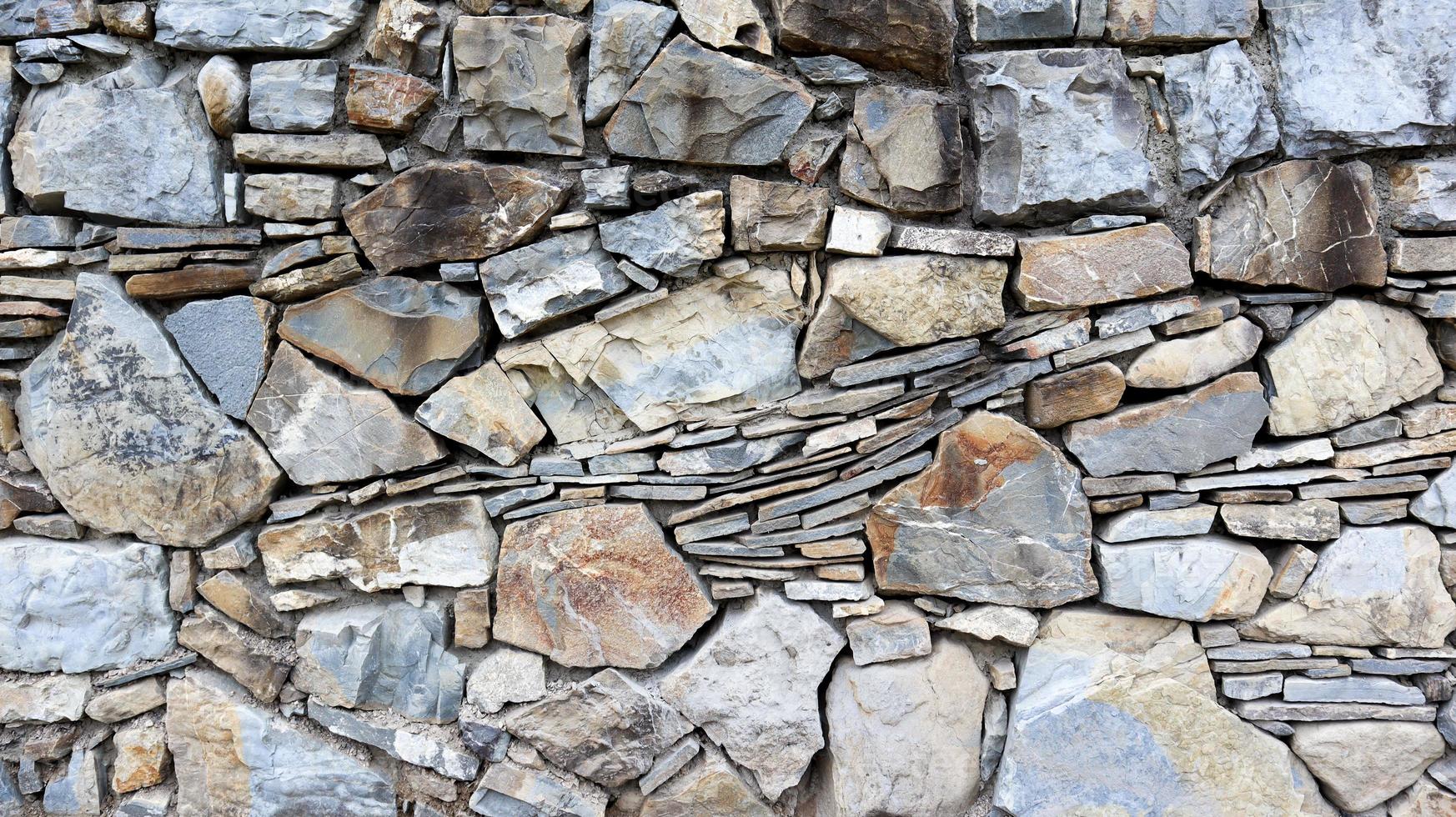 la trama del muro di pietra. fondo di struttura della parete di pietra del vecchio castello. muro di pietra come sfondo o texture. parte di un muro di pietra, per lo sfondo o la trama. modello colore grigio design in stile moderno foto