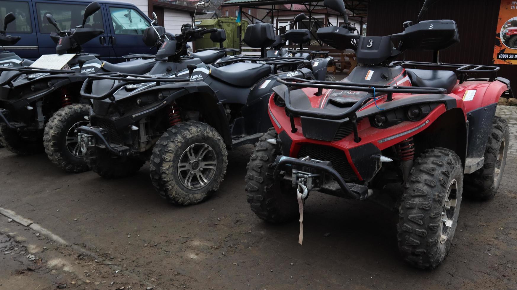 Ucraina, yaremche - 20 novembre 2019. molti atv parcheggiati su una strada sterrata, primi piani. auto a quattro ruote, fuoristrada. grandi ruote con gambe potenti. tour in montagna nei carpazi. foto