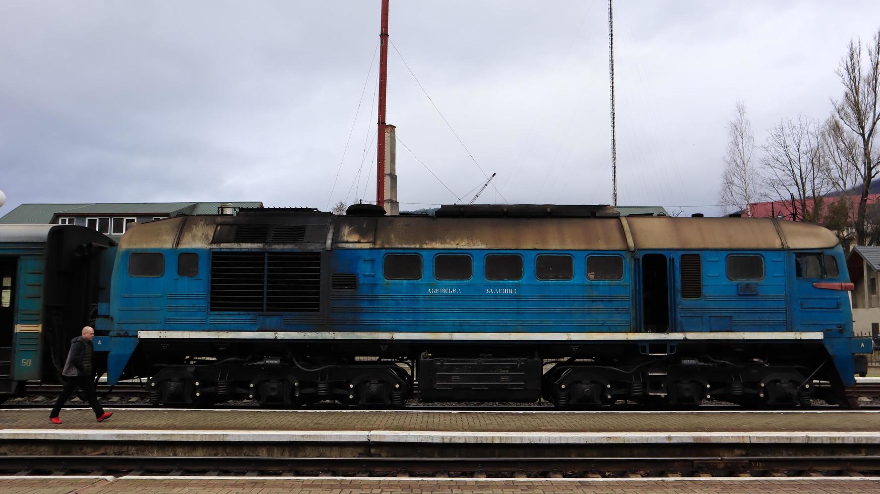 Ucraina, yaremche - 20 novembre 2019. treno alla stazione su uno sfondo di montagne. vagoni ferroviari unici sulla piattaforma nella città di yaremche. vecchio treno passeggeri diesel. stazione ferroviaria. foto