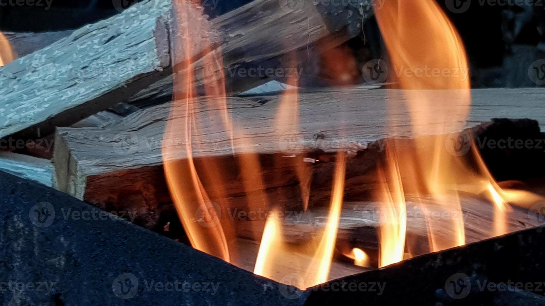 danza della fiamma, barbecue su fuoco aperto. fuoco nella griglia con legna ardente. preparare il carbone prima di grigliare carne o pesce all'aperto. fiamma nel camino. preparazione barbecue foto