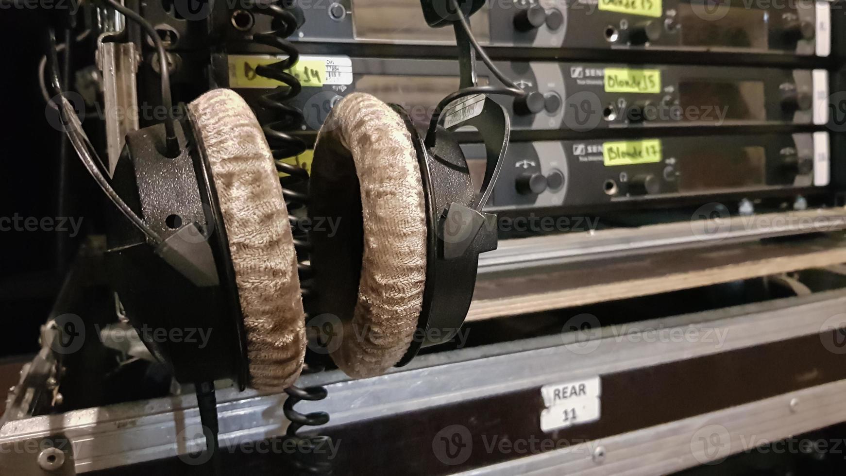 cuffie tra le apparecchiature del tecnico del suono nel backstage di una sala da concerto o di uno spettacolo televisivo foto