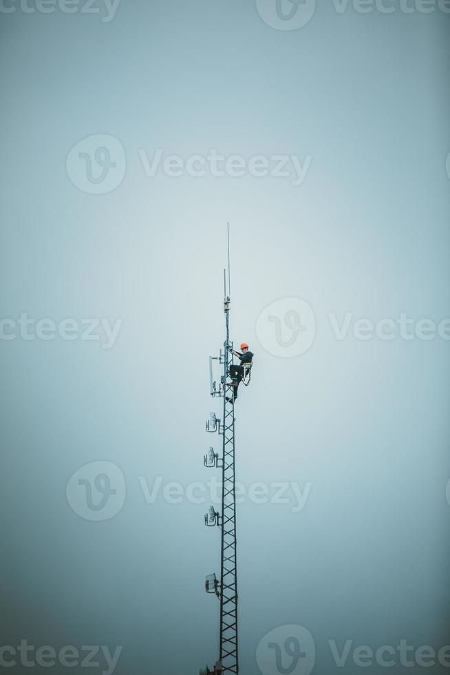 torre dell'antenna rampicante dell'operatore delle telecomunicazioni foto