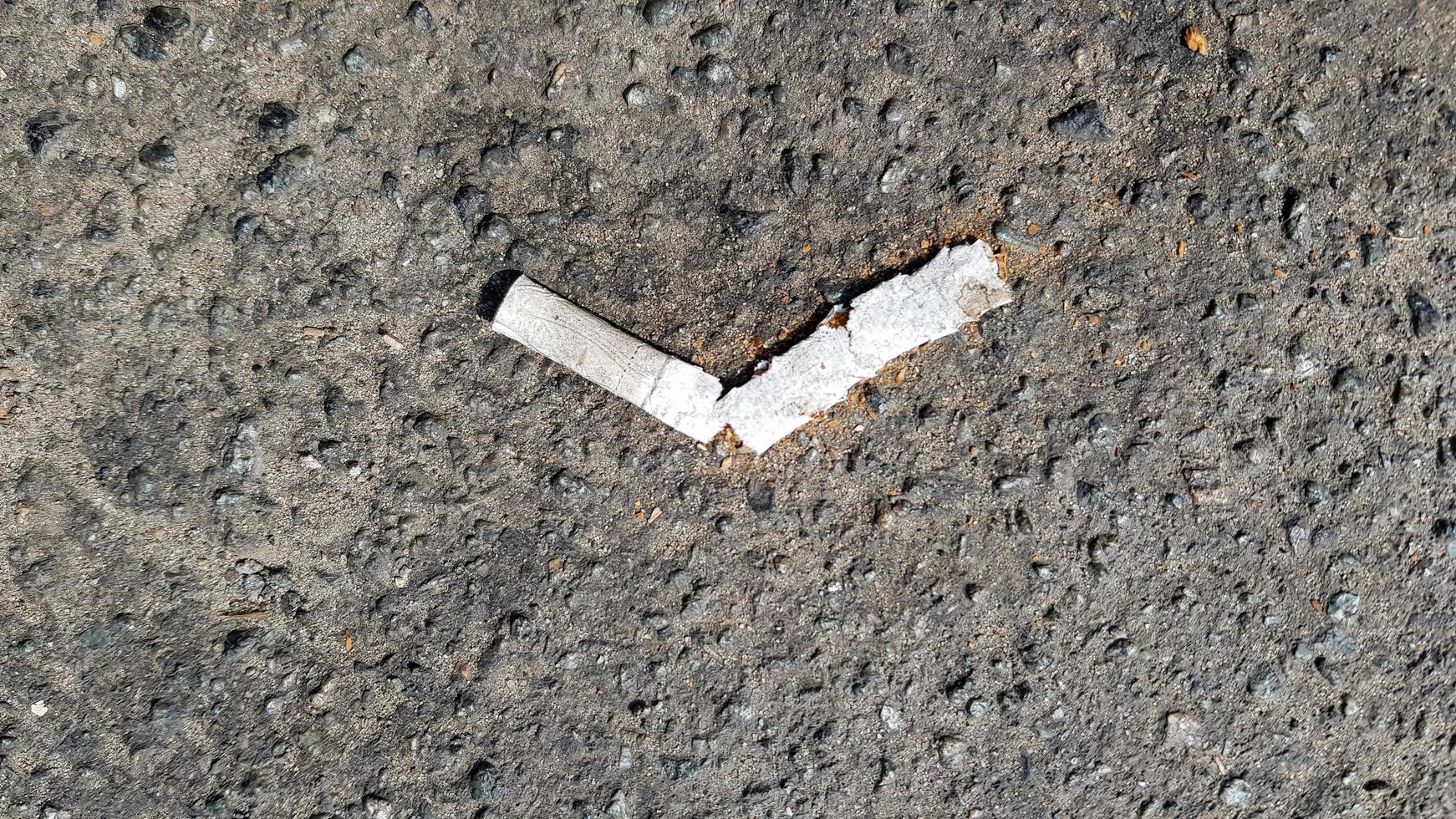 primo piano di un mozzicone di sigaretta rotto su asfalto con spazio di copia. giornata internazionale senza tabacco. giornata mondiale contro sigarette, nicotina e tabacco foto