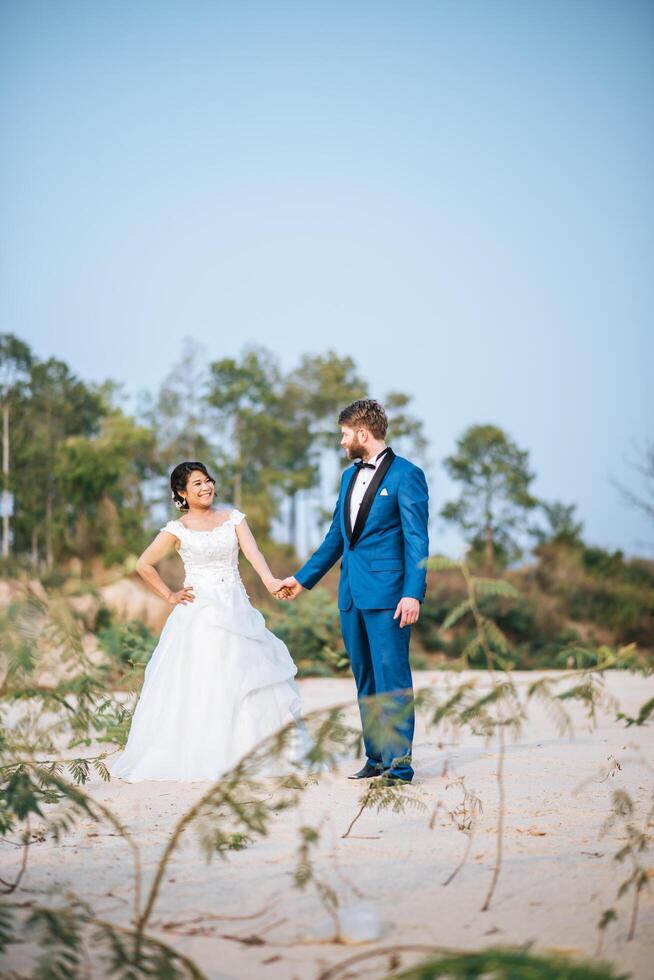 la sposa asiatica e lo sposo caucasico hanno tempo di romanticismo e sono felici insieme foto