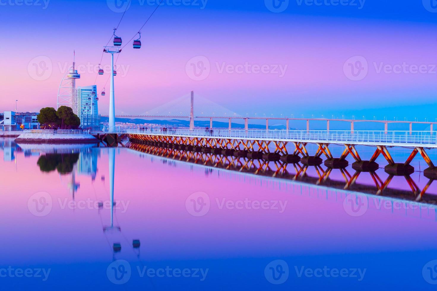 paesaggio urbano serale di lisbona specchiato nell'acqua, portogallo. vista del parco delle nazioni - parque das nacoes al crepuscolo foto