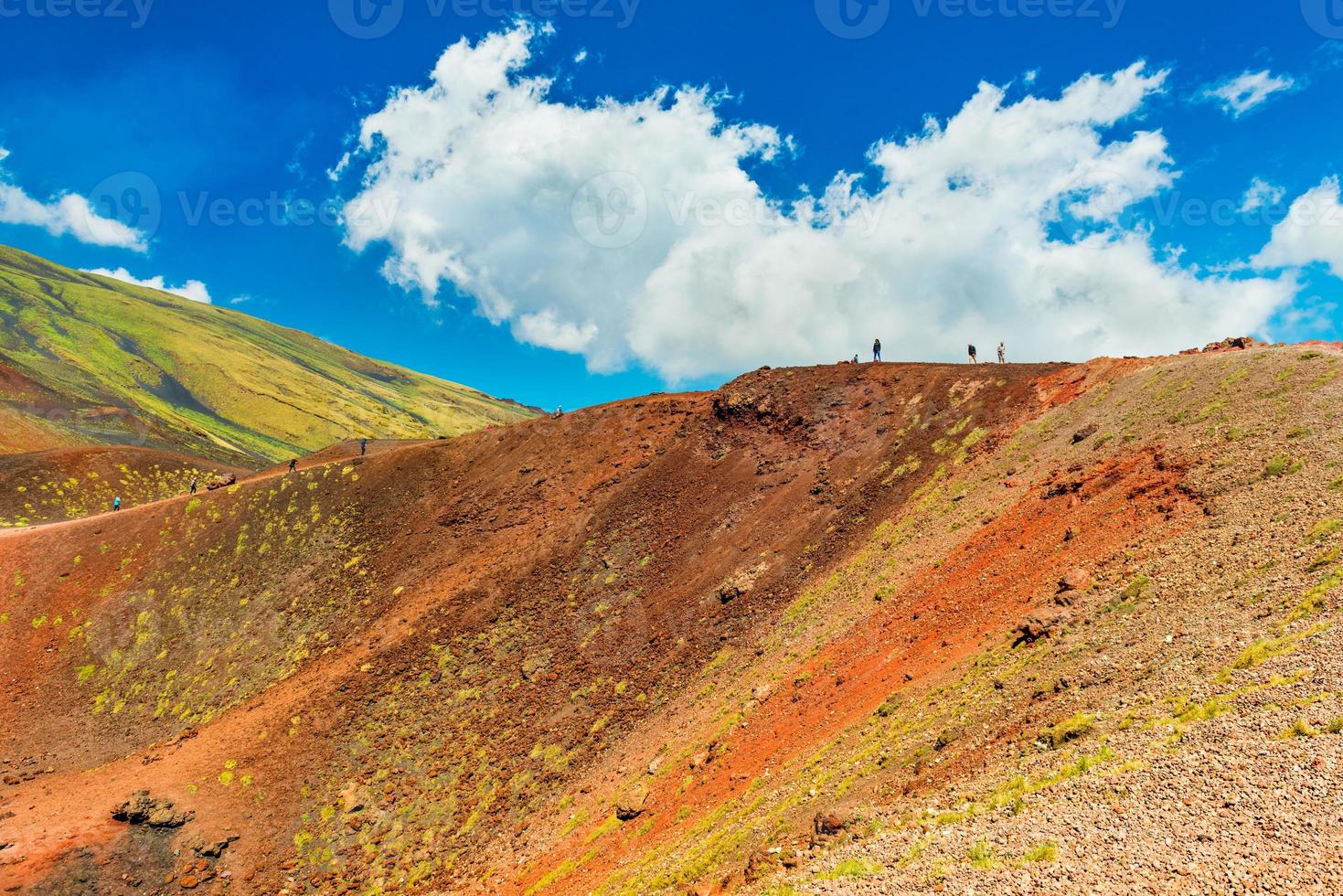 bellissime colline laviche colorate con un gruppo di persone che fanno escursioni a un cratere vulcanico. monte etna, sicilia, italia foto