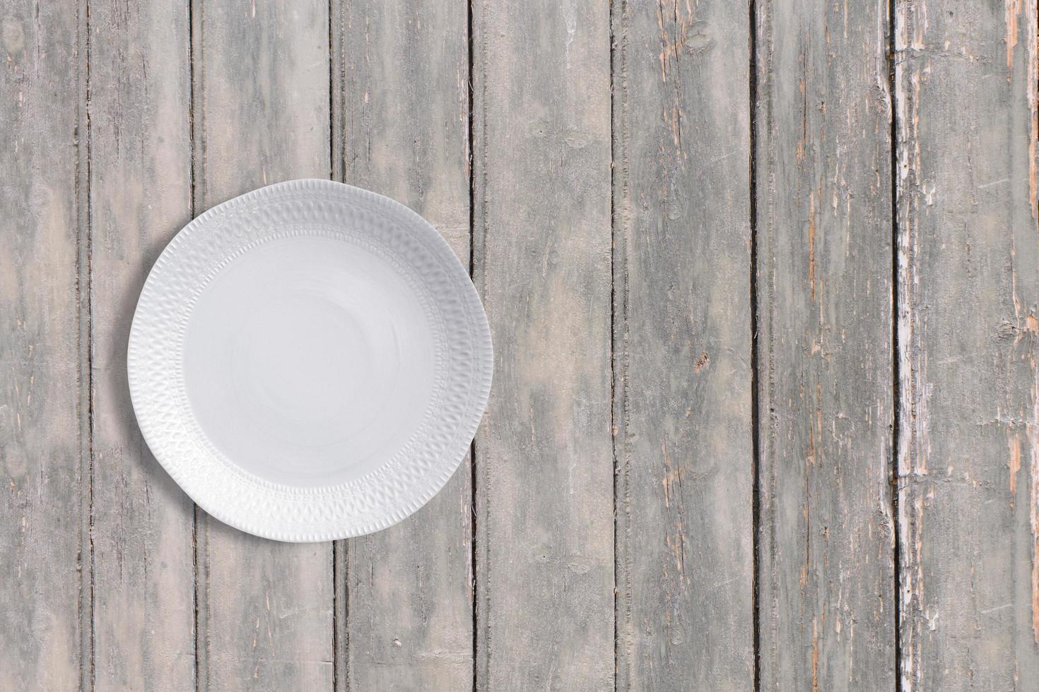 vista superiore piatto bianco sul tavolo vintage in legno scuro. aggiunto spazio copia per il testo, adatto allo sfondo del tuo concetto di cibo o bevande. foto