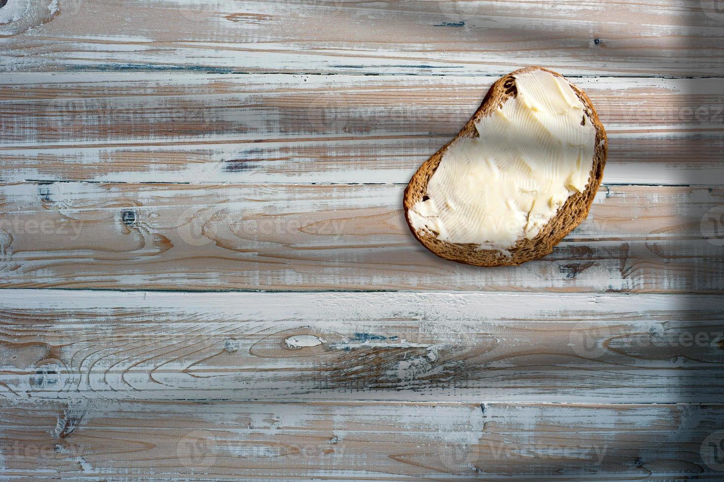 fetta di pane al cioccolato con crema di burro bianco sul tavolo di legno. foto