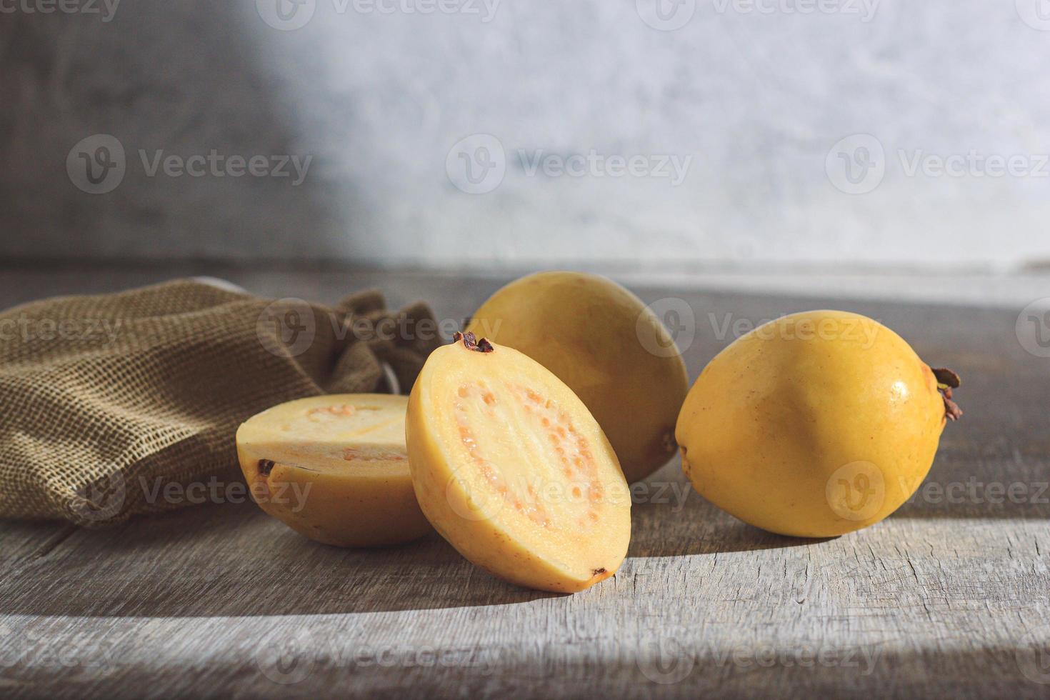 guaiava gialla su fondo di legno. vitamina c, dieta sana di frutta. foto