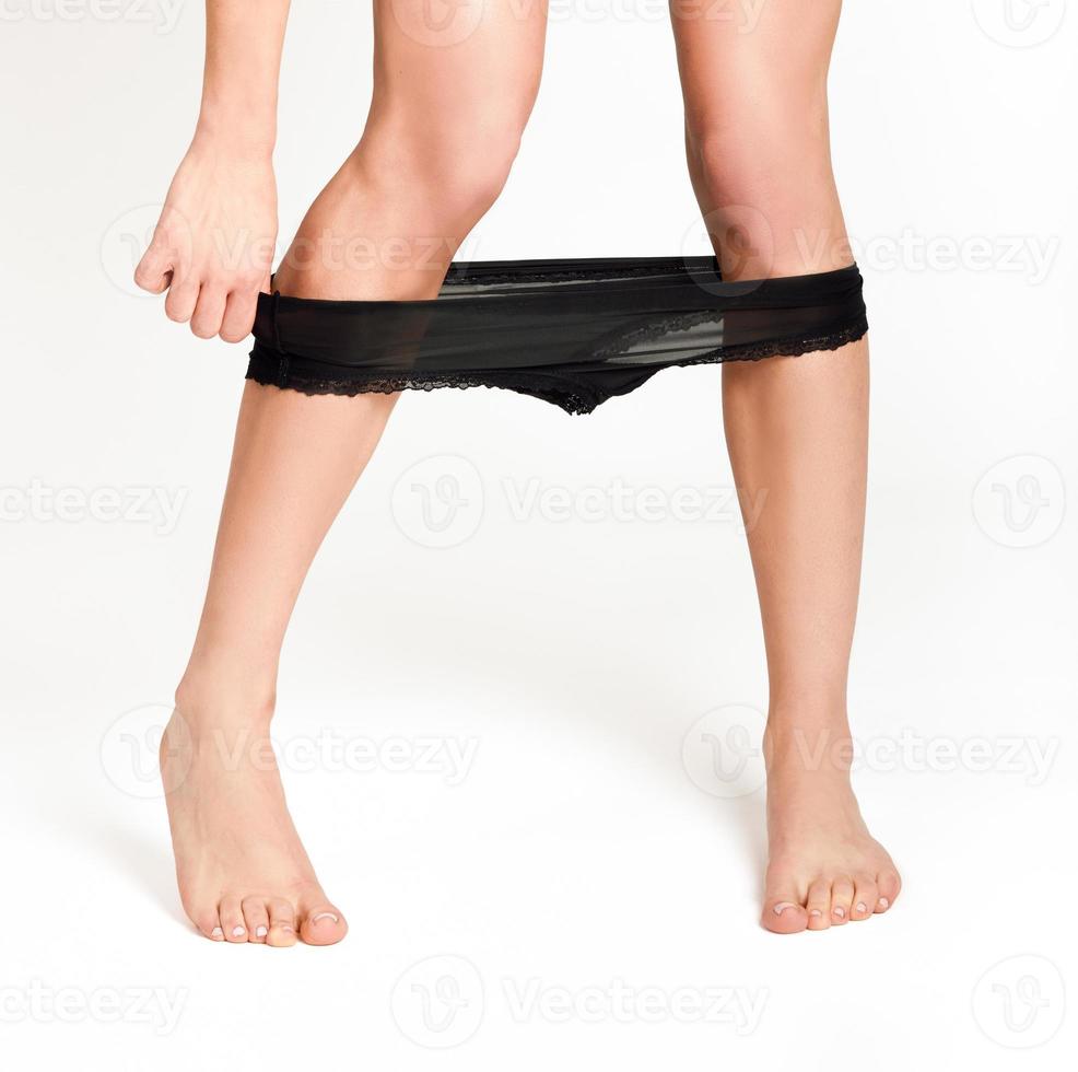 donna con gambe sexy che le prendono le mutandine nere foto