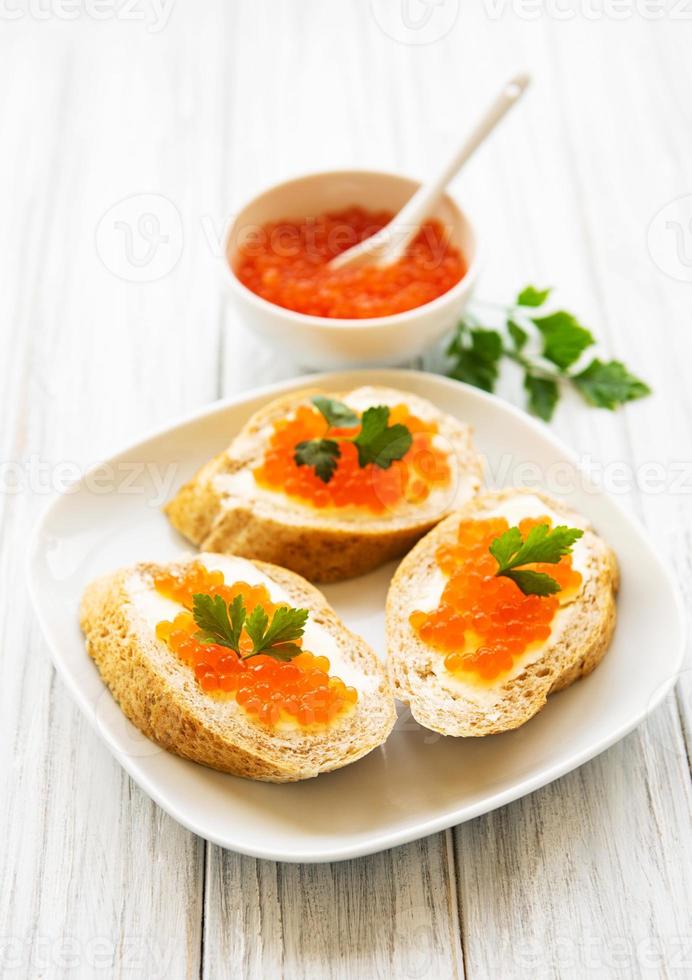 caviale rosso in ciotola e panini foto