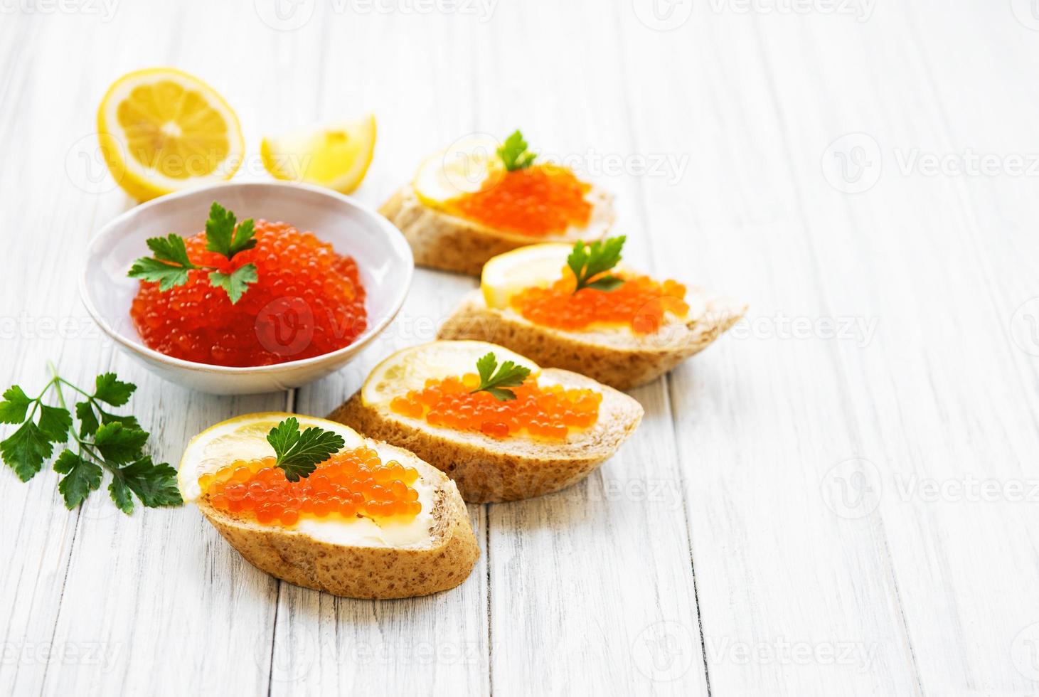 caviale rosso in ciotola e panini foto