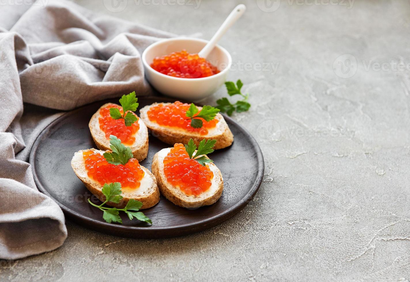 caviale rosso in ciotola e panini foto