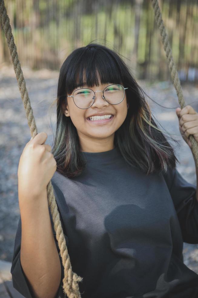 faccia sorridente di felicità dell'adolescente asiatico in parco aperto foto