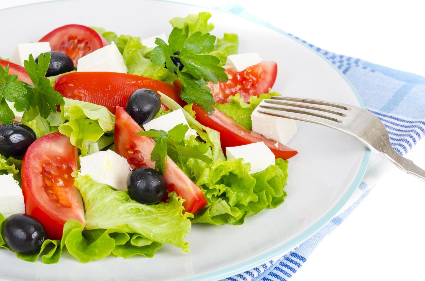 uno stile di vita sano. insalata di dieta di verdure con olive e formaggio di capra su sfondo bianco. foto