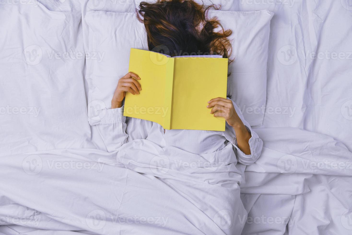 giovane donna che dorme nel letto. vista dall'alto della giovane donna sdraiata che dorme bene a letto. la ragazza che ha letto il libro a letto e dorme. dormire rilassarsi, rilassarsi, dormire, educazione, foto