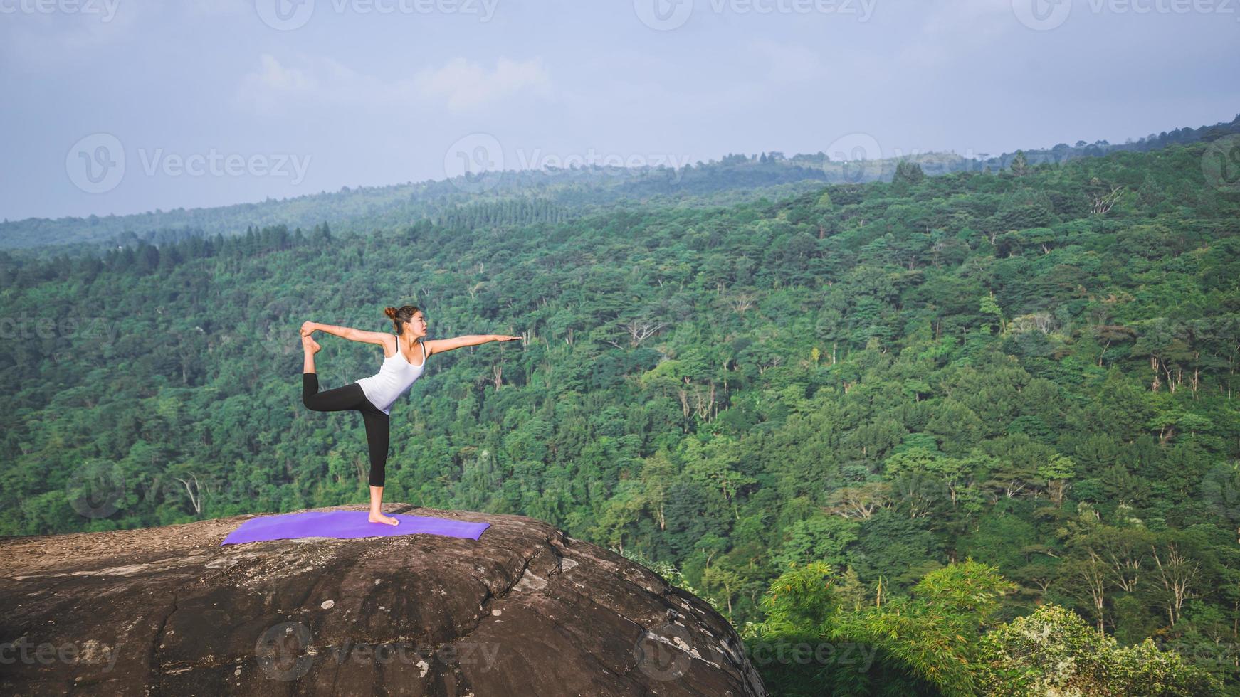 le donne asiatiche si rilassano durante le vacanze. gioca se lo yoga. sulla rupe rocciosa della montagna. natura delle foreste di montagna in thailandia. giovane donna che pratica yoga nella felicità femminile della natura. esercizio di yoga foto