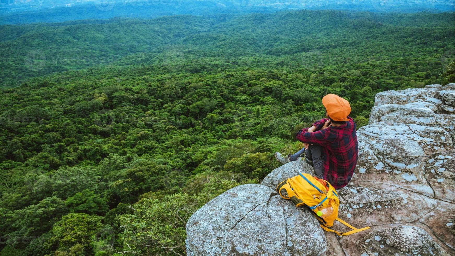 donna che viaggia per la libertà godendo di uno sguardo alla natura di montagna sulle scogliere contro uno splendido scenario durante il viaggio estivo rilassante all'aperto. zaino da viaggio foto