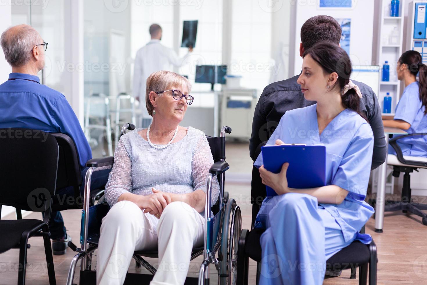 infermiera che parla con una donna anziana disabile foto