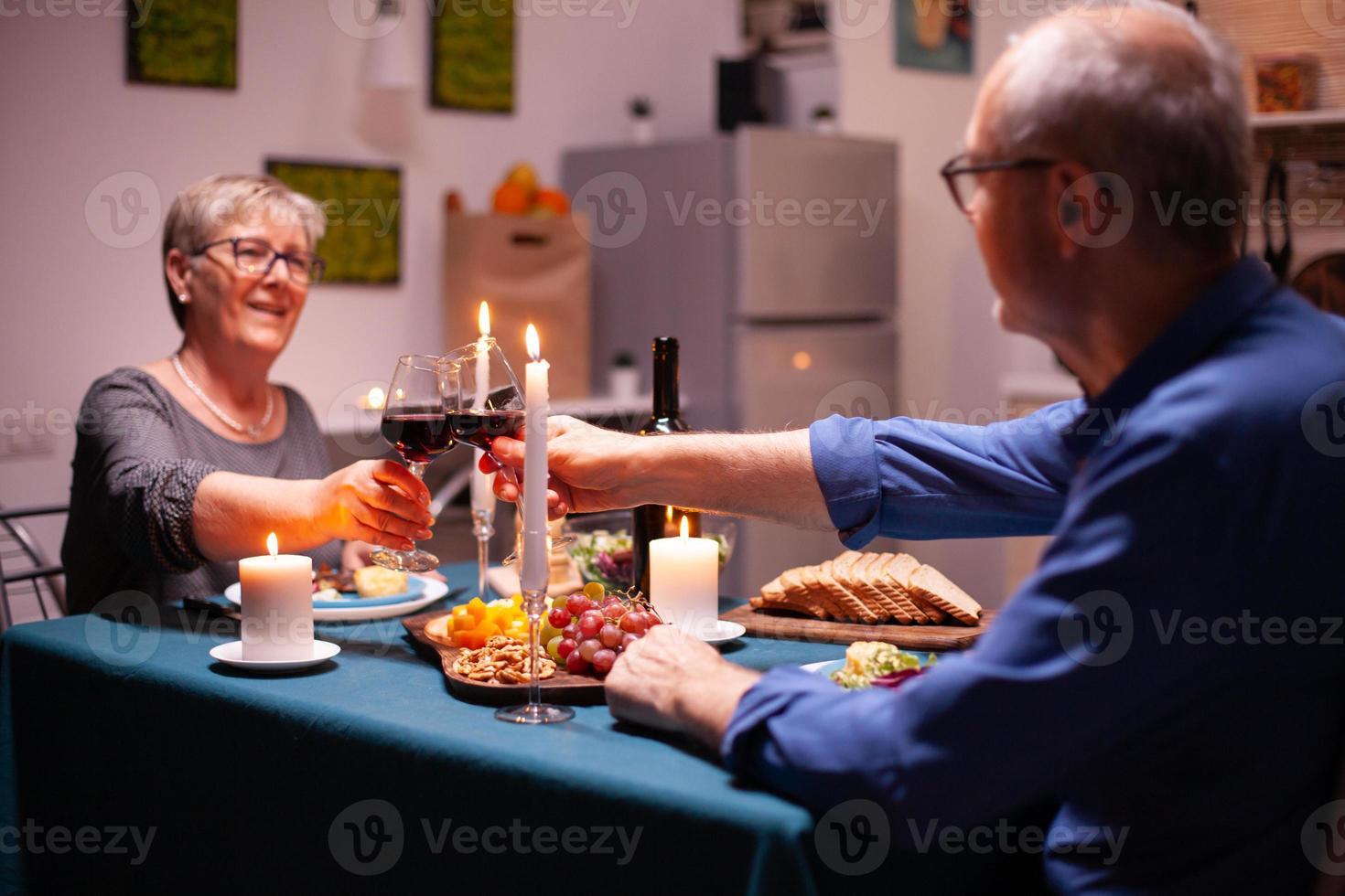 coppia senior che tiene bicchieri di vino foto