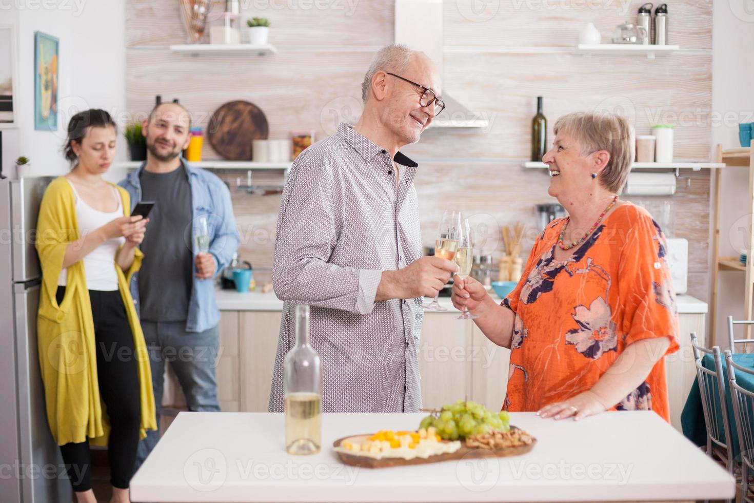 coppia di anziani che brinda con il vino foto