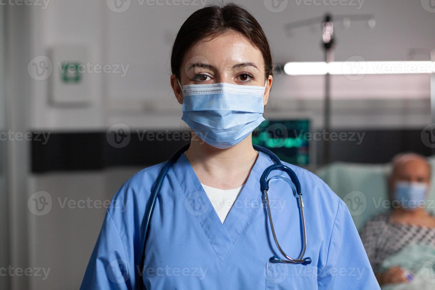 medico specialista sanitario che indossa una maschera chirurgica nella stanza d'ospedale foto