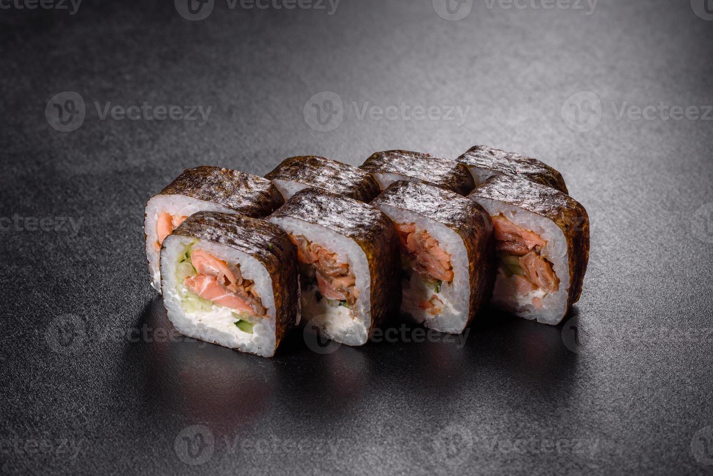 tradizionale delizioso rotolo di sushi fresco impostato su sfondo nero foto