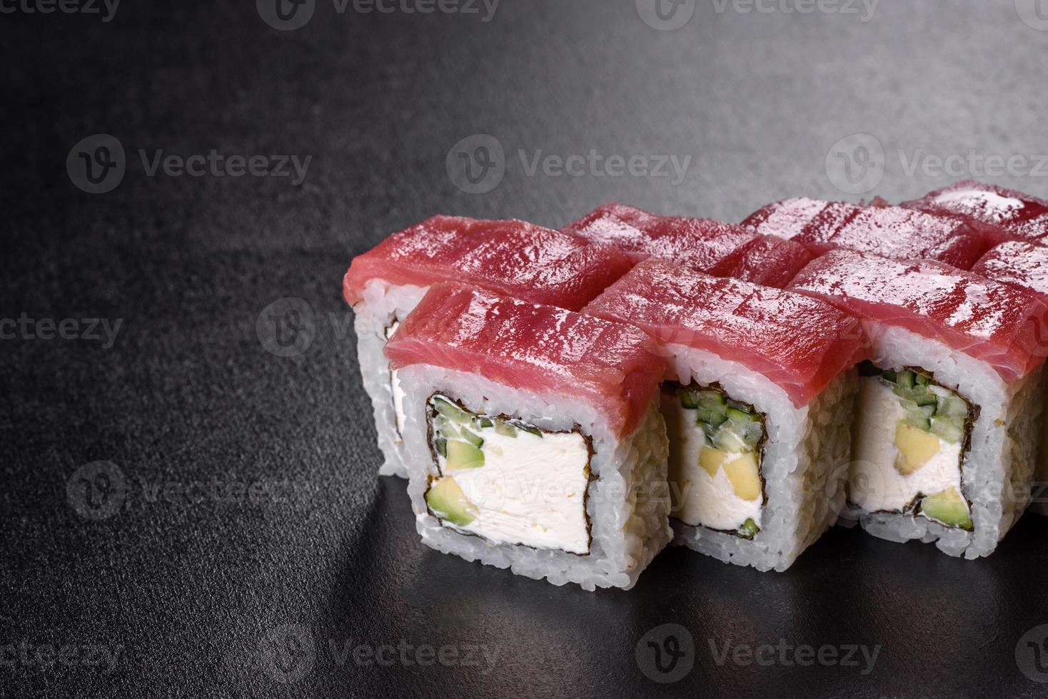 tradizionale delizioso rotolo di sushi fresco impostato su sfondo nero foto