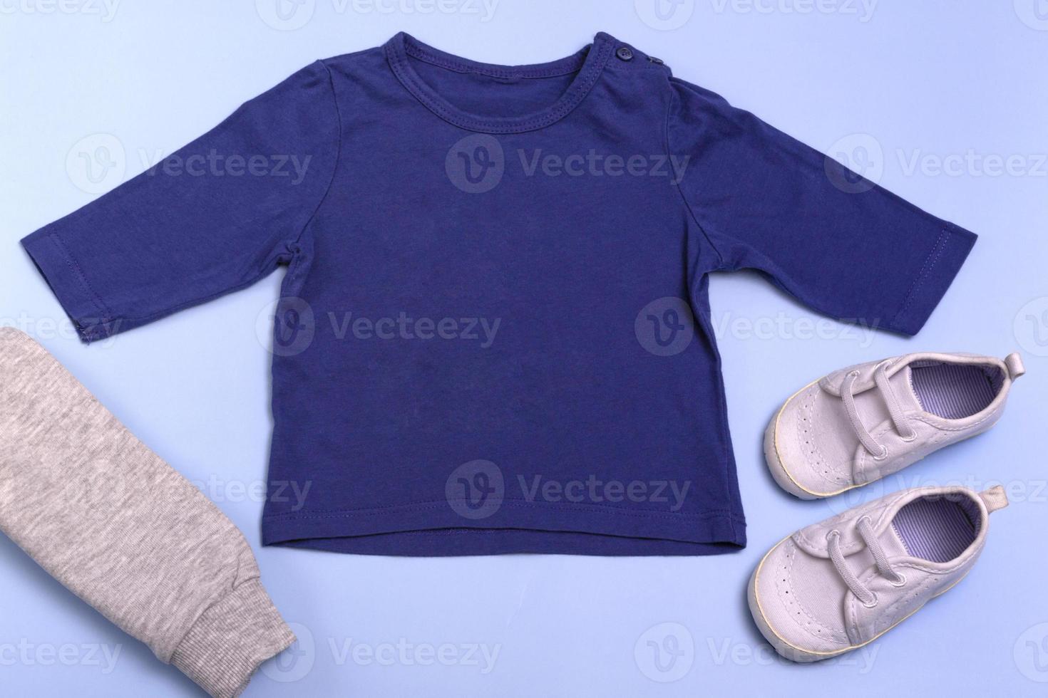 mockup per la progettazione e il posizionamento di loghi, pubblicità. raglan blu per bambini, polo, camicetta vista dall'alto, mockup su sfondo blu. foto