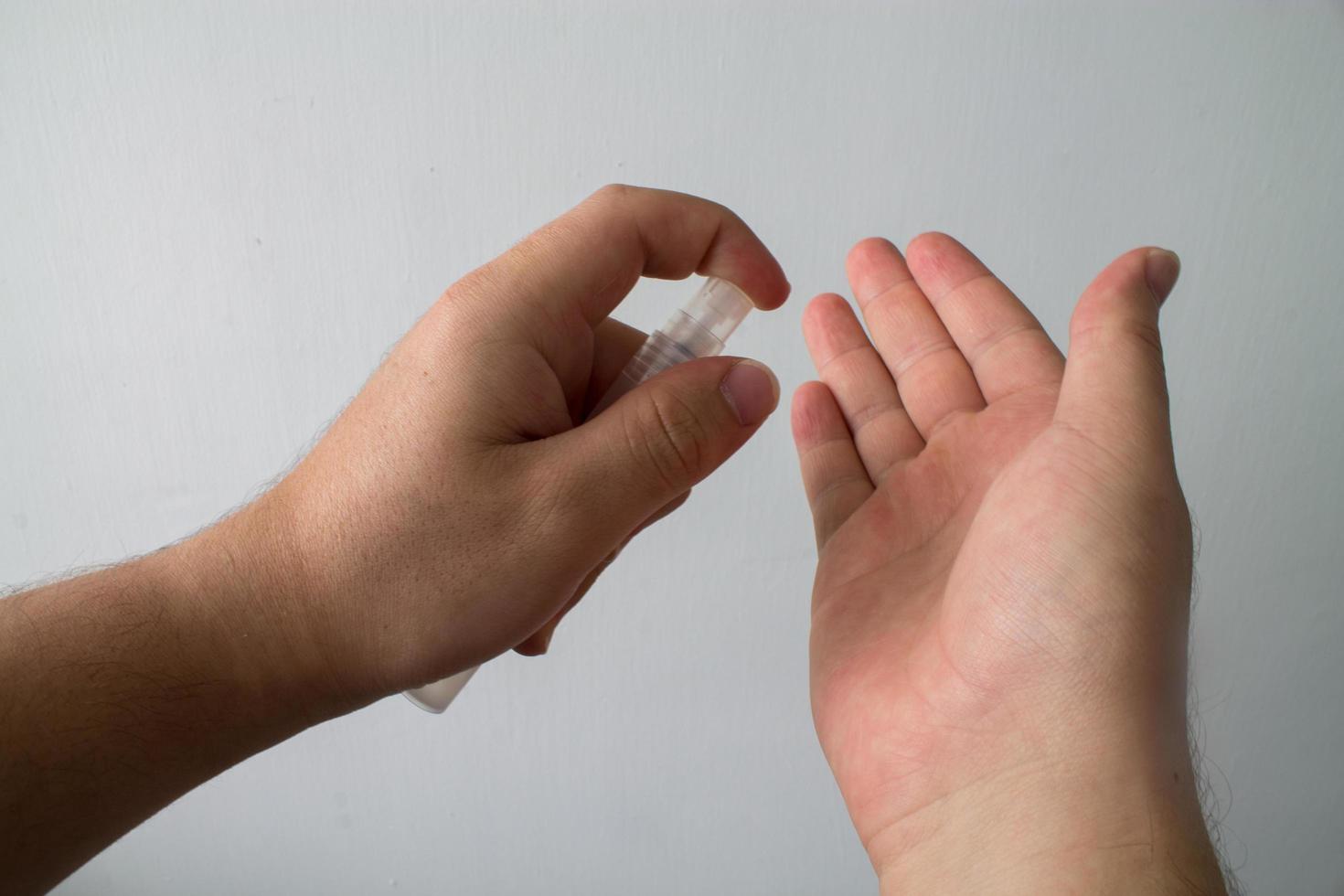 un uomo si disinfetta le mani con gel antibatterico. foto