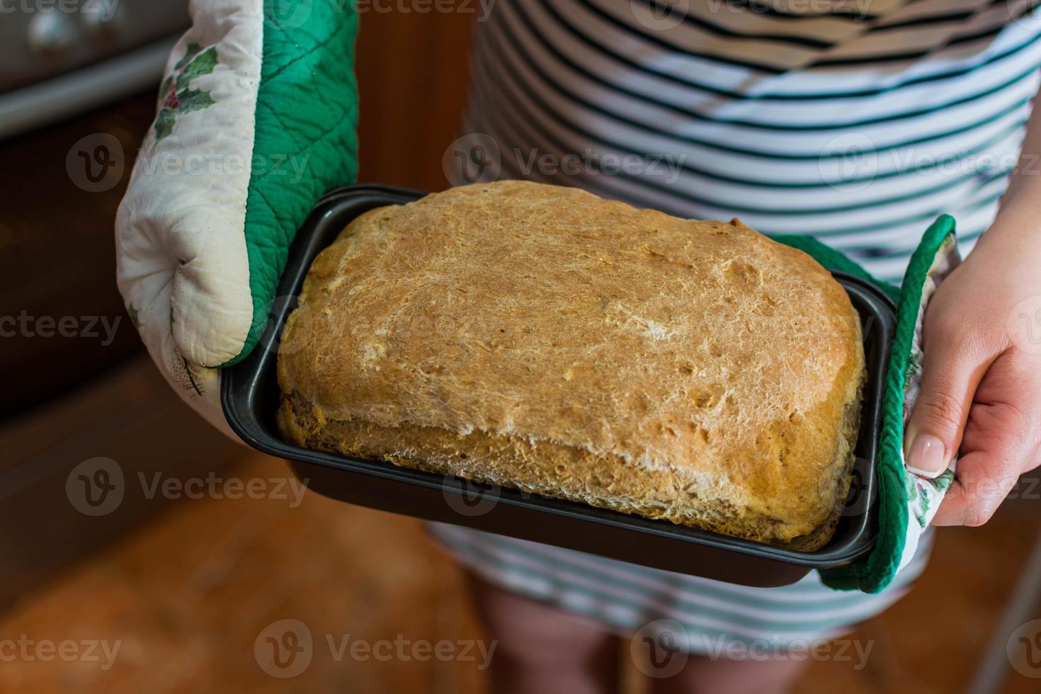 pane fatto in casa. pane fresco, fragrante, appena sfornato nelle mani di una ragazza. foto