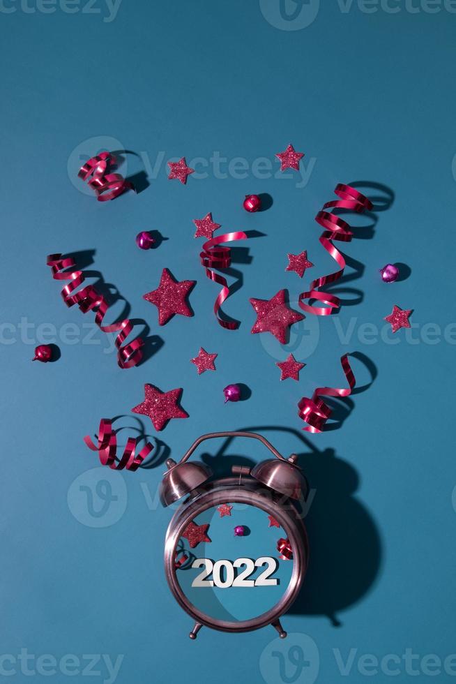 buon natale felice anno nuovo piatto con sveglia, stelle, stelle filanti numero 2022 formato verticale foto