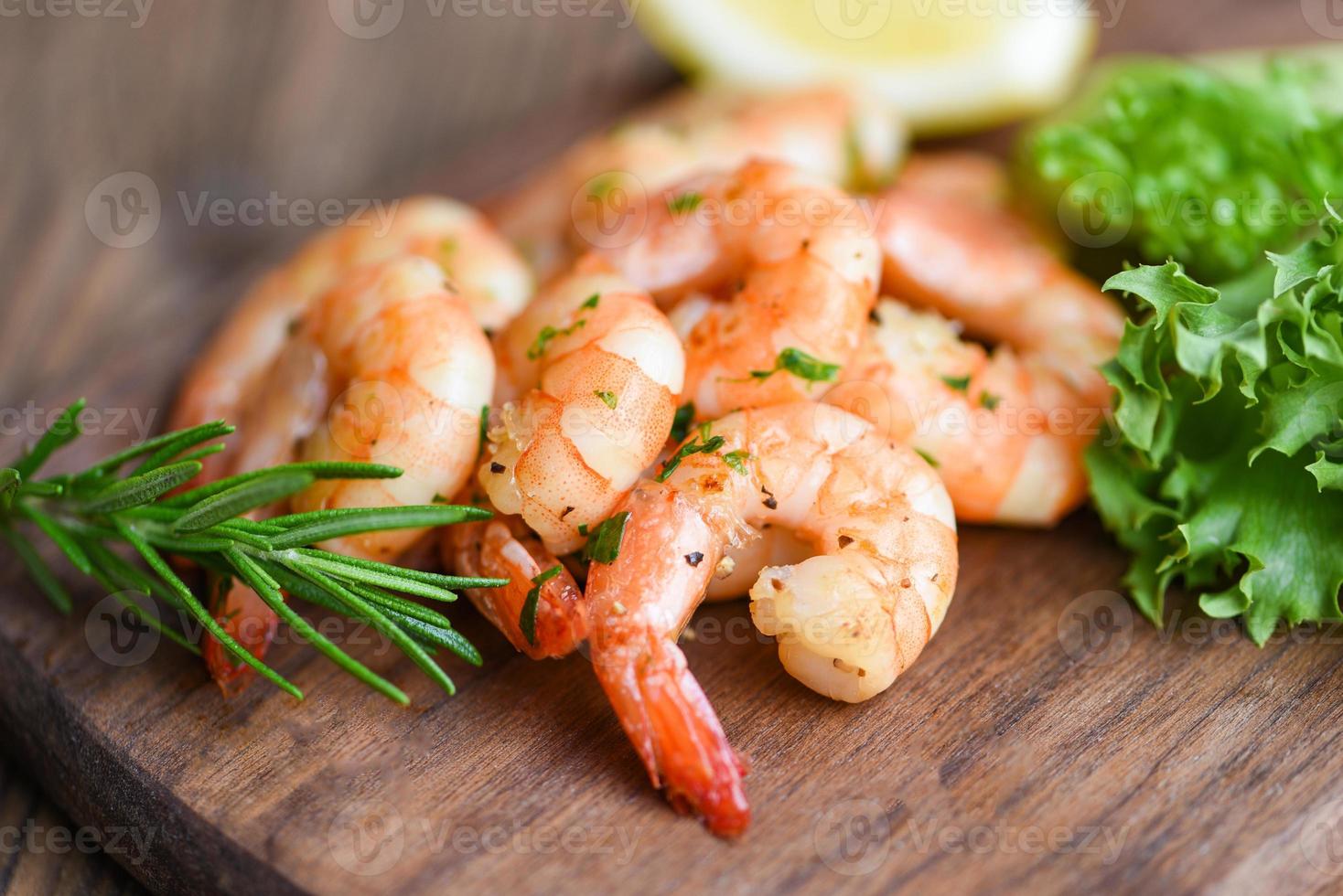 Insalata di gamberi alla griglia condimento delizioso spezie su tagliere di legno sfondo appetitosi gamberi cotti gamberi al forno frutti di mare shelfish con rosmarino limone e lattuga foto