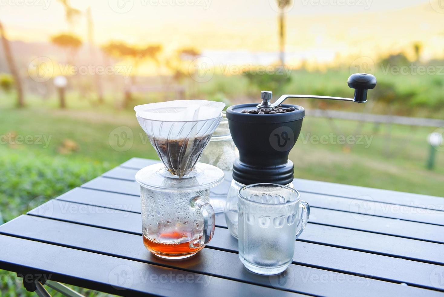 barista di caffè a goccia che versa acqua sulla birra filtrata, prepara il caffè a goccia a mano in un barattolo di vetro all'aperto. foto