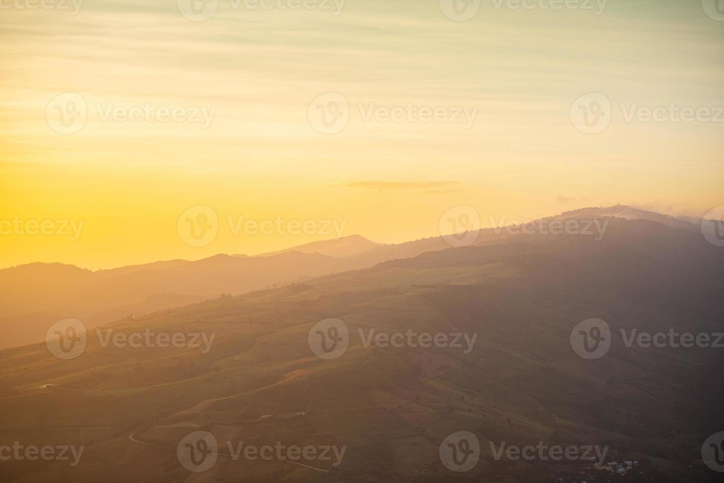 paesaggio alba sulla montagna con campo ed erba prato bel cielo giallo o tramonto. foto