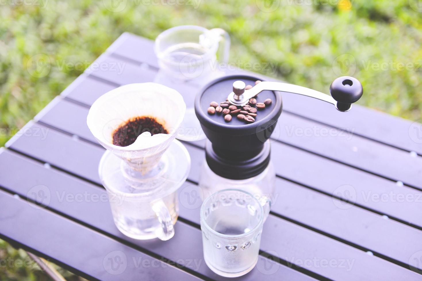 barista di caffè a goccia che versa acqua sulla birra filtrata, prepara il caffè a goccia a mano in un barattolo di vetro all'aperto. foto