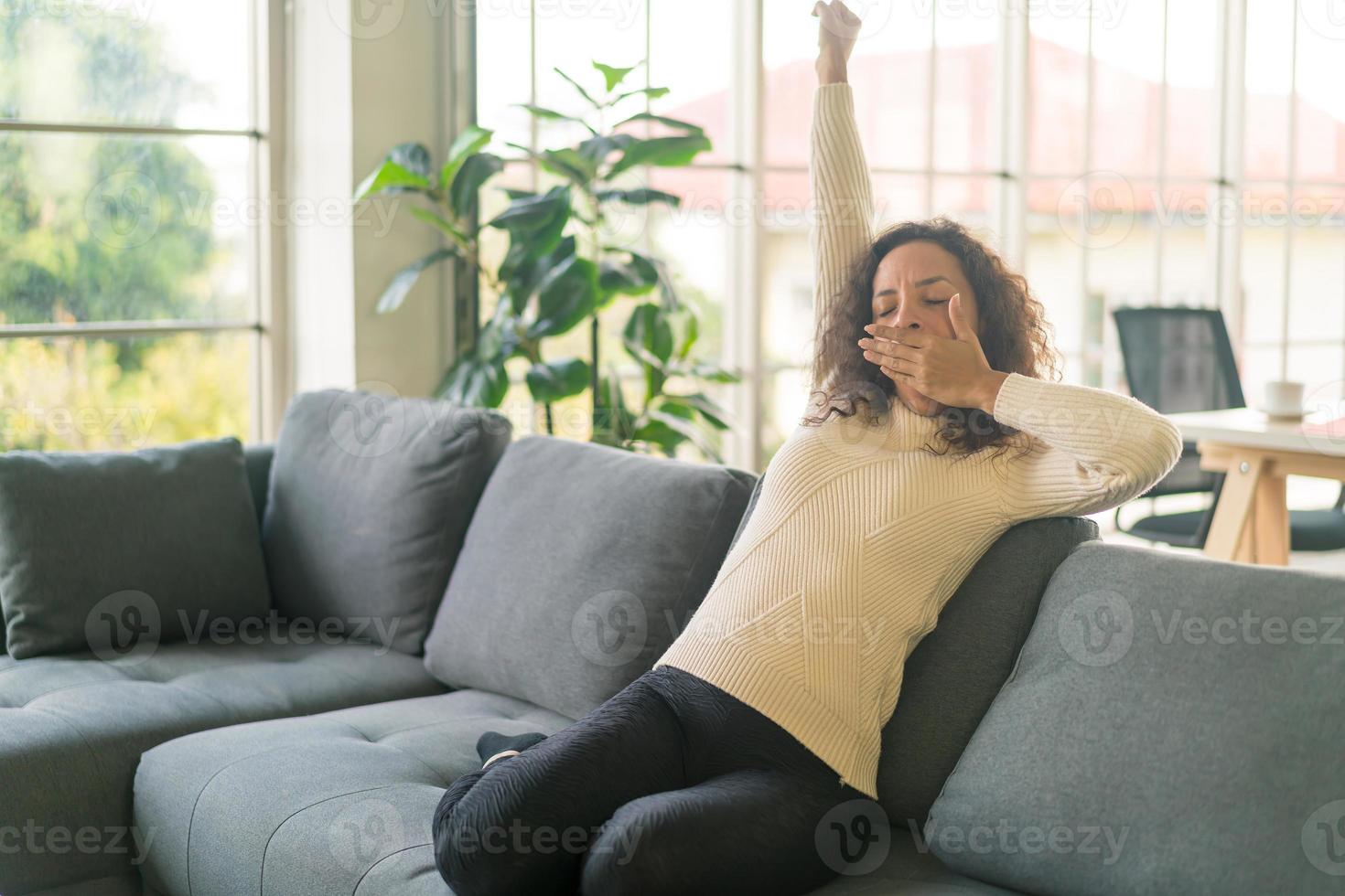 donna latina sul divano con sensazione di pigrizia foto