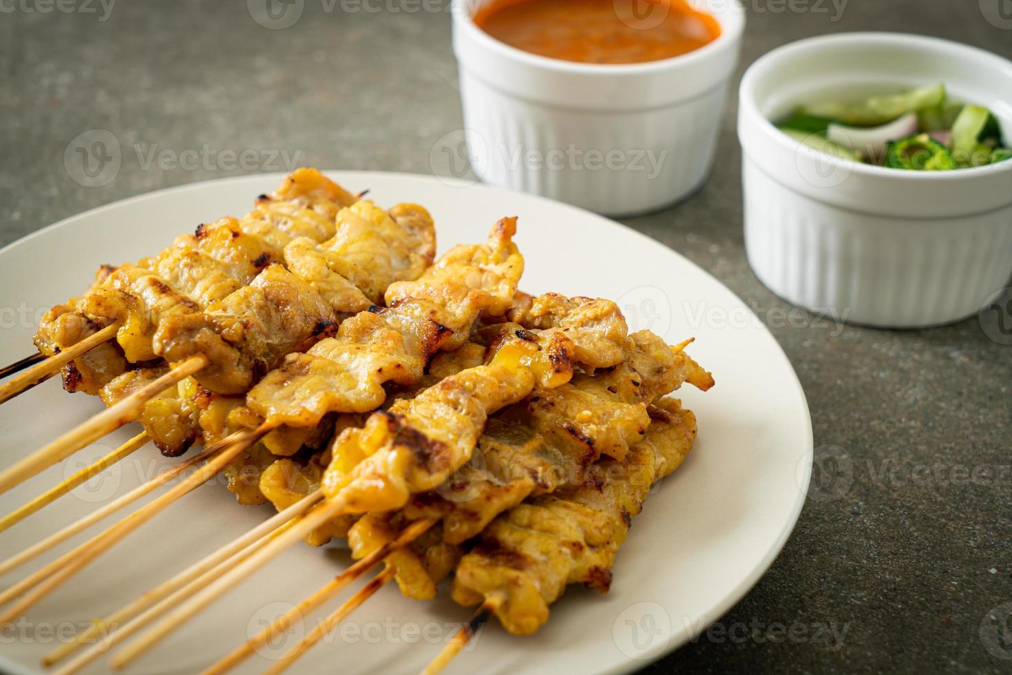 satay di maiale con sottaceti di salsa di arachidi che sono fette di cetriolo e cipolle in aceto foto